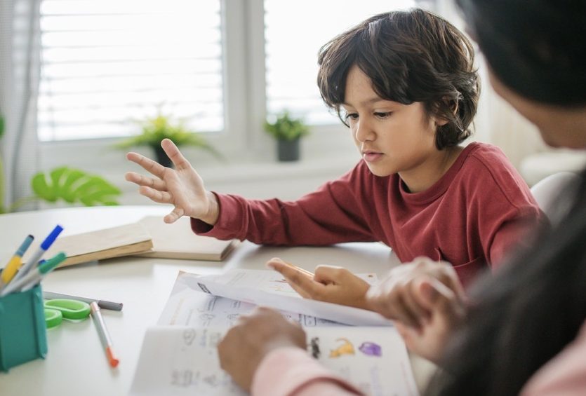 Boy doing homework with mother