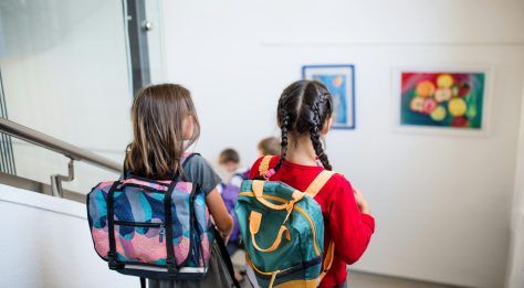two girls in school uniform walking down stairs