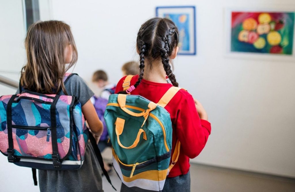 two girls in school uniform walking down stairs
